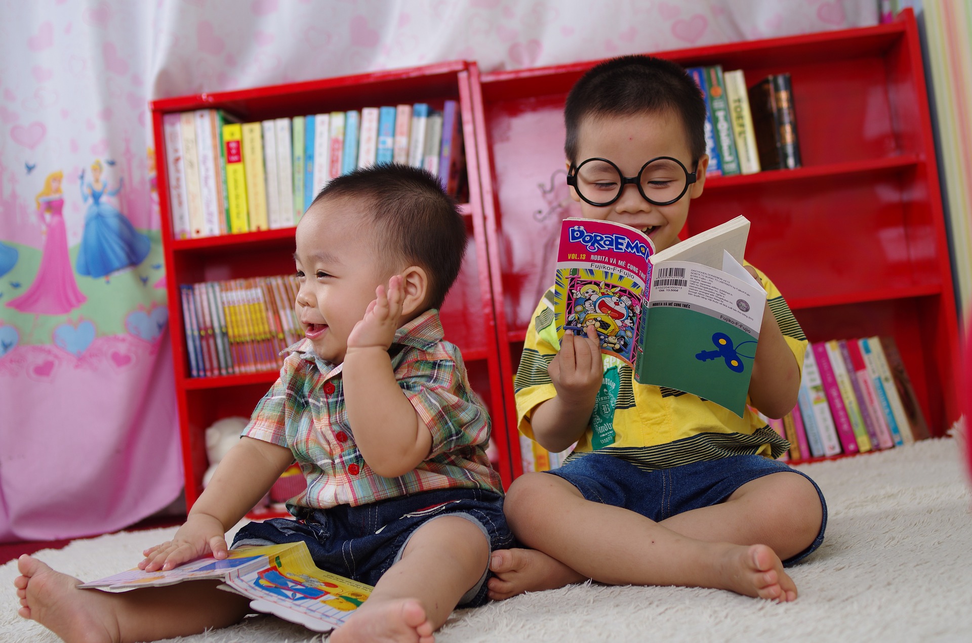 Two young boys reading books