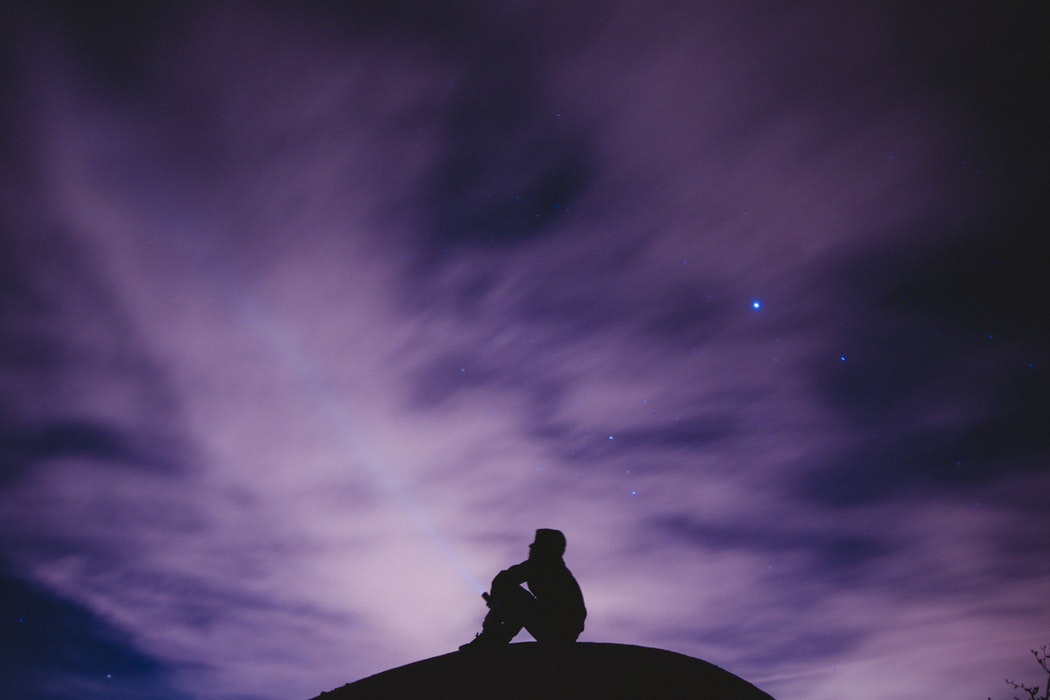 Silhouette of a young person stargazing