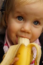 Image of small child eating a banana.