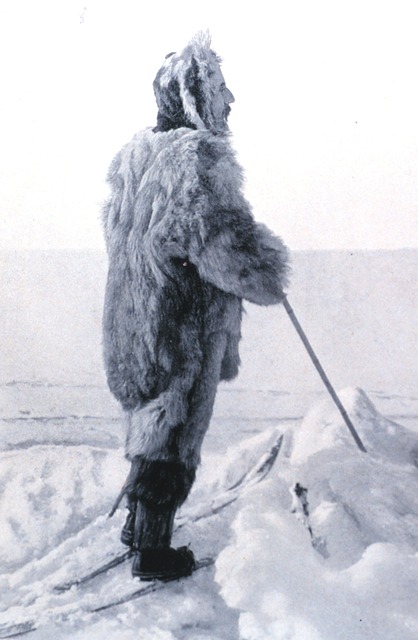 Man dressed in furs covered in snow.