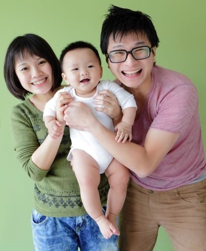 Young Asian couple holding their adorable baby.