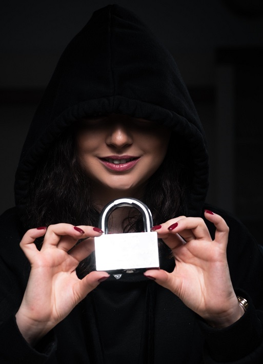 woman in shadows holding lock representing cybersecurity
