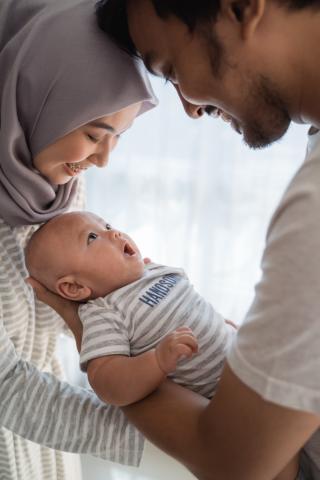 young Muslim couple holding their baby