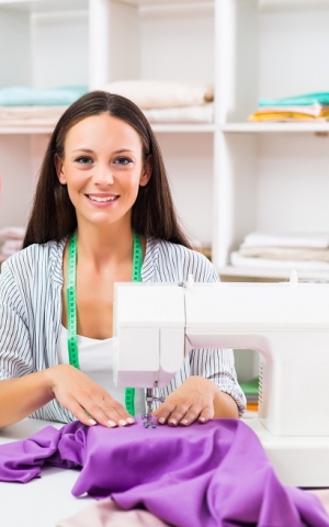 Woman sewing purple fabric on a sewing machine