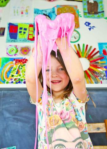 Young girl with a handful of oobleck