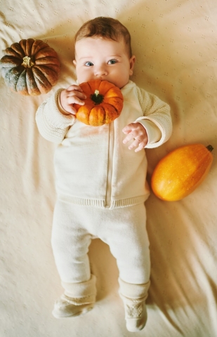 Adorable baby with pumpkins.